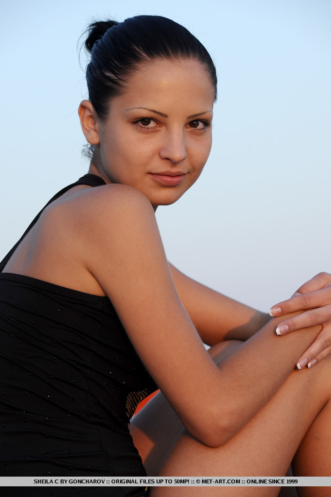 Naked, bathing cutie on a rugged coastal terrain.